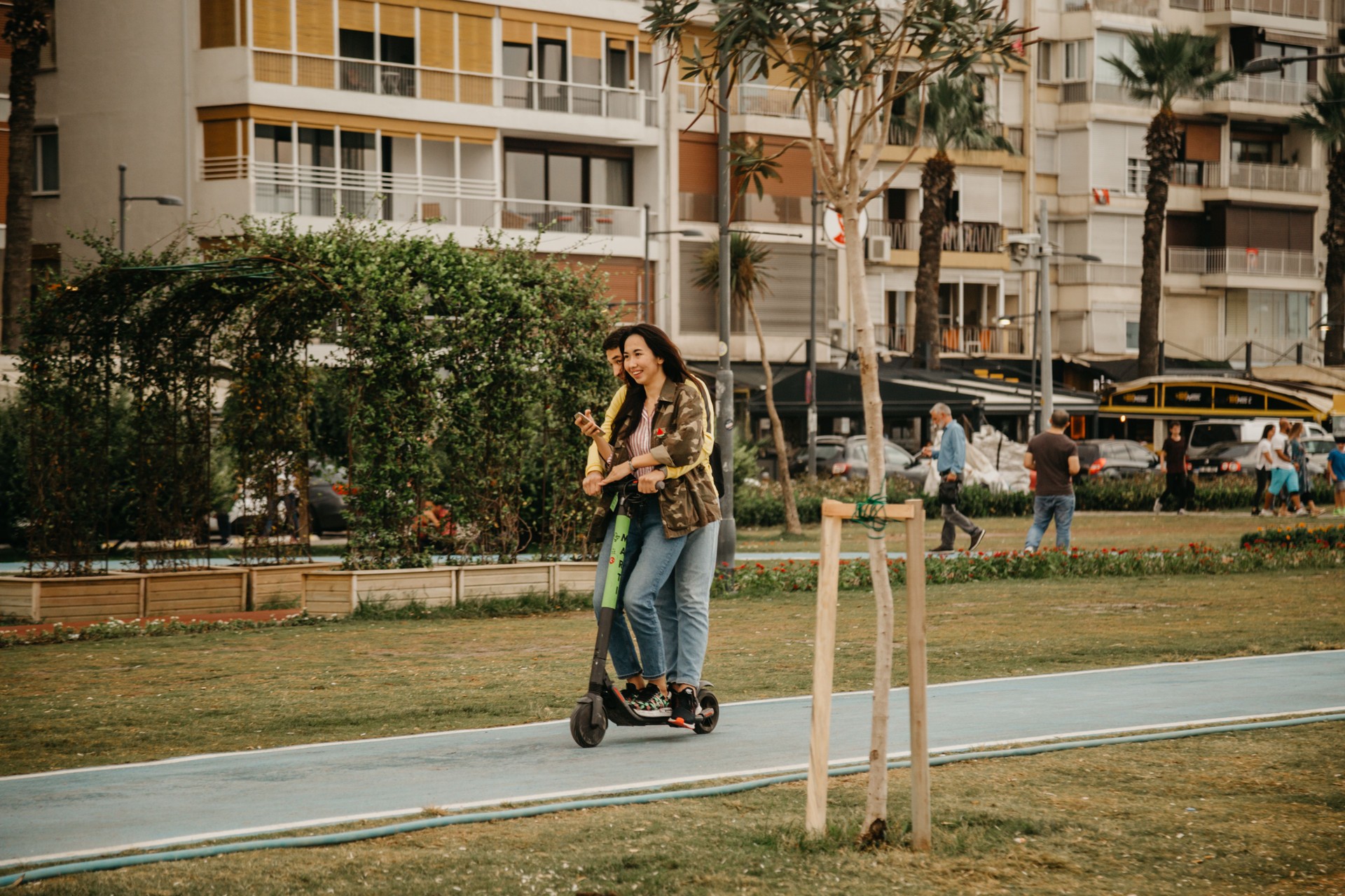 couple riding scooters on bike path