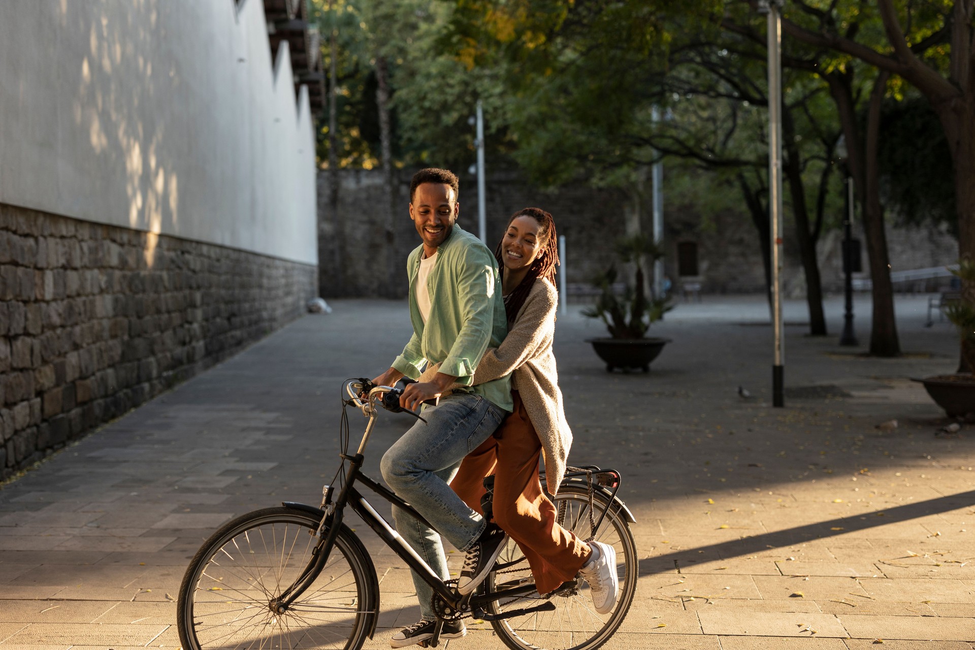 African american couple, having fun in the city park riding a bicycle